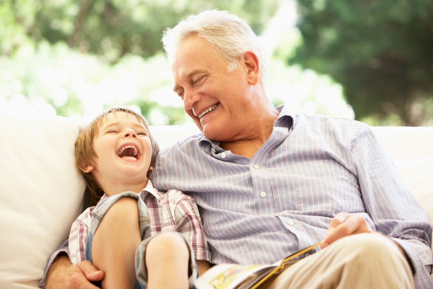 Grandfather on the couch reading with his grandson
